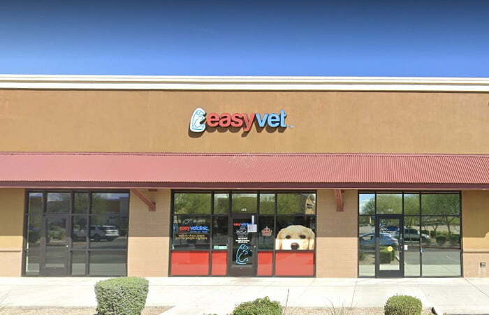 Exterior of an Easyvet clinic with red doors and a large window featuring a dog image.